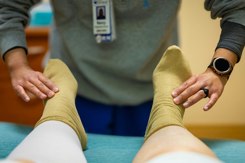 Un trabajador sanitario examina los pies de un paciente.